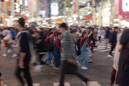 TOKYO, JAPAN - OCTOBER 30, 2019: Shibuya Crossing in Tokyo, Japan. The most famous intersection in the world. Blurry beacause of the panning.