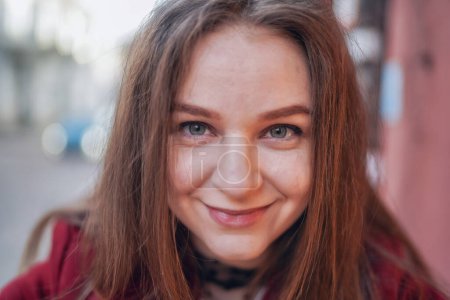 Photo for Close up Face of Beautiful Young Girl in Vilnius Old Town, Lithuania. Wearing Red jacket and Black Trousers. Beautiful Spring Day. Curious Face - Royalty Free Image