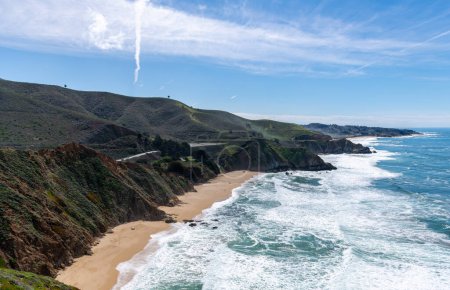 Téléchargez les photos : Gray Whale Cove State Beach in California. California State Route 1 in Background. Ocean Waves and Blue Sky in Background. Landscape. Devil's Slide - en image libre de droit