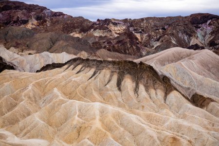 Téléchargez les photos : Zabriskie Point. Il fait partie de la chaîne Amargosa située à l'est du parc national Death Valley en Californie, aux États-Unis. Un homme au sommet de la montagne. - en image libre de droit