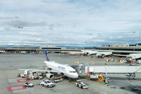 Téléchargez les photos : SAN FRANCISCO, CALIFORNIA - APRIL 04, 2019: San Francisco International Airport. United Airlines Boeing and Ground Service in Background. Delta Airlines Airplane is Taking off. - en image libre de droit