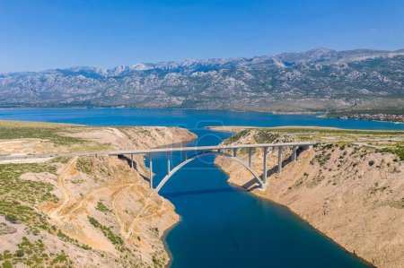 Photo for Maslenica Bridge Most in Croatia. The Maslenica Bridge is a deck arch bridge carrying the state road spanning the Novsko Zdrilo strait of the Adriatic Sea. Beautiful Landscape in Background. - Royalty Free Image