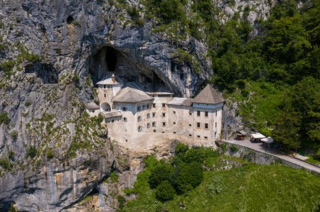 Photo for Predjama Castle in Slovenia, Europe. Renaissance castle built within a cave mouth in south central Slovenia, in the historical region of Inner Carniola. It is located in the village of Predjama. Drone - Royalty Free Image