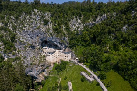 Photo for Predjama Castle in Slovenia, Europe. Renaissance castle built within a cave mouth in south central Slovenia, in the historical region of Inner Carniola. It is located in the village of Predjama. Drone - Royalty Free Image