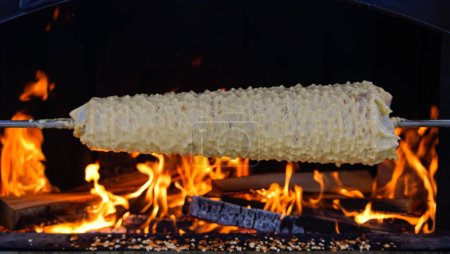 Photo for Sakotis is a Polish Lithuanian traditional spit cake. It is a cake made of butter, egg whites and yolks, flour, sugar, and cream, cooked on a rotating spit in an oven or over an open fire - Royalty Free Image