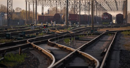 Foto de Railway Network In Lithuania. Radviliskis is well known railway capital in Lithuania. Beautiful evening sunset light and cars in background. - Imagen libre de derechos