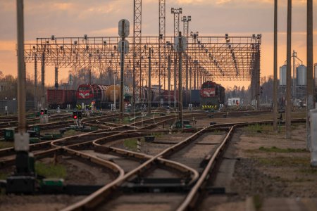 Foto de Railway Network In Lithuania. Radviliskis is well known railway capital in Lithuania. Beautiful evening sunset light and cars in background. - Imagen libre de derechos
