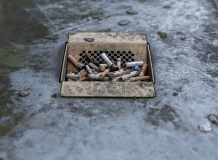 Foto de Cigarette Butts in ashtray on the public trash can in England, London. Dirty - Imagen libre de derechos