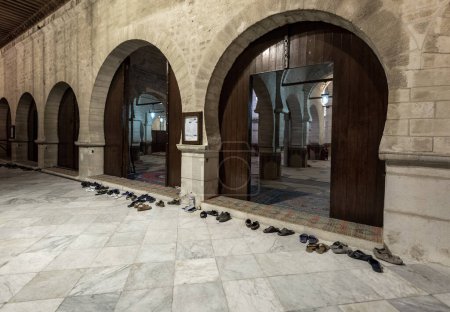 Téléchargez les photos : Great Mosque of Sousse in Tunisia. People Shoes in front of entrance right before evening worship. Friday evening. - en image libre de droit