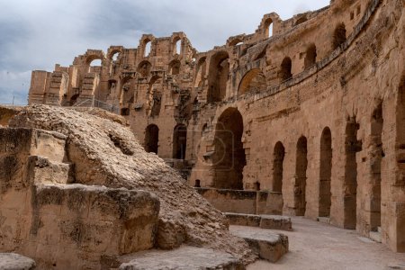 Téléchargez les photos : Amphithéâtre d'El Jem en Tunisie. L'amphithéâtre est situé dans la ville moderne d'El Djem, en Tunisie, anciennement Thysdrus, dans la province romaine d'Afrique. Elle est inscrite au patrimoine mondial de l'UNESCO depuis 1979. - en image libre de droit