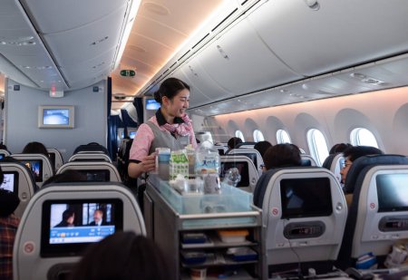 Téléchargez les photos : Japan ANA Airlines and Boeing 787 Dreamliner interior with People And ANA Cabin Crew Members working for passengers. - en image libre de droit