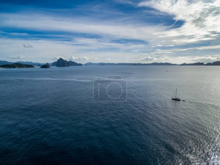 Téléchargez les photos : Single boat in Sea Close to El Nido Shore in Palawan, Philippines. Beautiful Islands in Background. - en image libre de droit