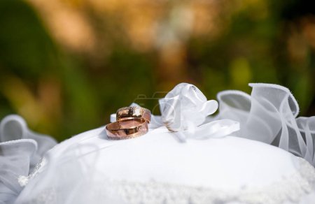Téléchargez les photos : Bague de mariage sur oreiller blanc. Contexte flou. - en image libre de droit