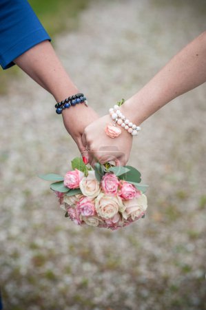 Foto de Mujer joven pareja sostiene la mano con ramo de flores de boda. - Imagen libre de derechos