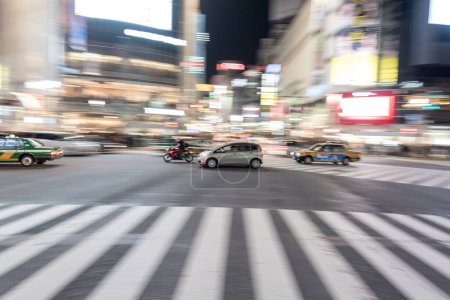 Téléchargez les photos : Shibuya District in Tokyo. Famous and busiest intersection in the world, Japan. Shibuya Crossing. Blurry Panning Car - en image libre de droit