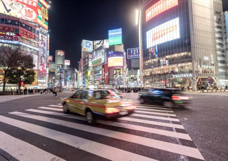 Téléchargez les photos : District de Shibuya à Tokyo. Intersection célèbre et la plus achalandée au monde, Japon. Shibuya Crossing. Voiture de panoramique floue - en image libre de droit