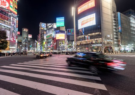 Téléchargez les photos : Shibuya District in Tokyo. Famous and busiest intersection in the world, Japan. Shibuya Crossing. Blurry Panning Car - en image libre de droit