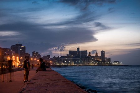 Foto de LA HABANA, CUBA - 22 de octubre de 2017: Paisaje urbano habanero con avenida Malecón y mar Caribe en segundo plano. Personas borrosas debido a la exposición prolongada - Imagen libre de derechos