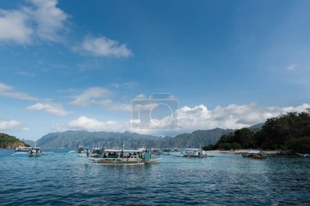 Photo for CORON, PHILIPPINES - JANUARY 30, 2018: Boats are waiting for tourists. CYC island and beach in Background.  Coron, Philippines. - Royalty Free Image
