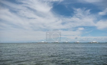 Photo for Malapascua coastline and boats in background. Clear Blue Sky and ocean water. - Royalty Free Image