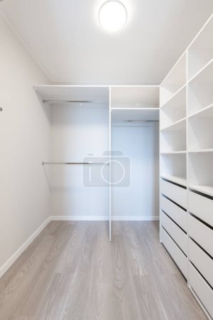 Photo for A Small White Walk in Closet With Shelves. Home Interior. - Royalty Free Image