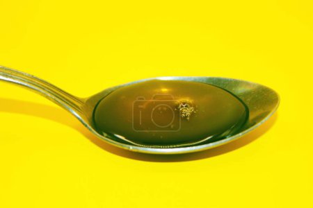 honey in a spoon, honey, honey on a yellow background