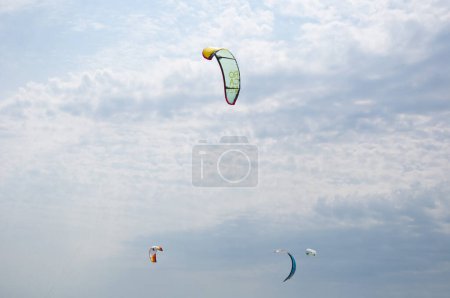 Photo for Henichesk, Ukraine - July 12, 2021: Kitesurfing athlete on kite with board. Foiling kiteboarding kitesurfing kiteboarder in ocean. Kitesurfing. Seascape with kitesurfer in waves. - Royalty Free Image