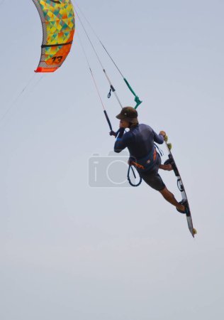 Photo for Henichesk, Ukraine - July 12, 2021: Ocean with kiteboarder riding kiteboard. Watersport adrenaline adventure activity. Kitesurfing. Active athlete on kiteboard hold control bar practicing kitesurfing. - Royalty Free Image