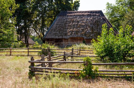 Authentic Ukrainian house in countryside. Summer village in Ukraine. Old folk thatched house. Ukrainian traditional rustic house. Rural countryside in summer ranch. Architecture.