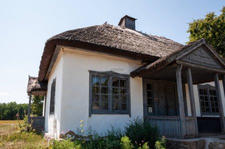 Authentic Ukrainian house in countryside. Summer village in Ukraine. Old folk thatched house. Ukrainian traditional rustic house. Rural countryside in summer ranch. Architecture. Entrance.