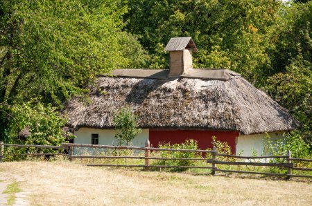 Authentic Ukrainian house in countryside. Summer village in Ukraine. Old folk thatched house. Ukrainian traditional rustic house. Rural countryside in summer ranch. Architecture Ukrainian heritage.