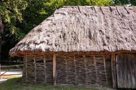 Authentic Ukrainian house in countryside. Summer village in Ukraine. Old folk thatched house. Ukrainian national traditional rustic house. Rural countryside in summer ranch. Architecture.