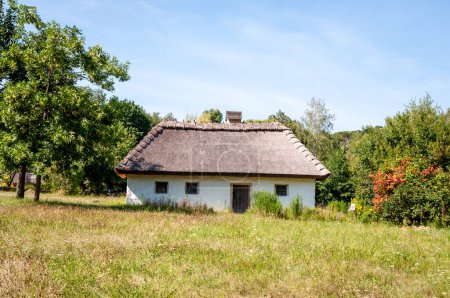 Authentic Ukrainian house in countryside. Summer village in Ukraine. Old folk thatched house. Ukrainian traditional rustic house. Rural countryside in summer ranch. Architecture farm.