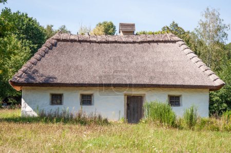 Authentic Ukrainian house in countryside. Summer village in Ukraine. Old folk thatched house. Ukrainian traditional rustic house. Rural countryside in summer ranch. Architecture. Old school.
