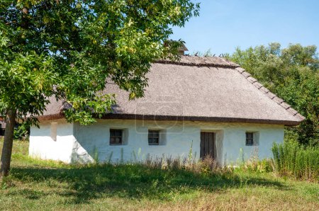 Authentic Ukrainian house in countryside. Summer village in Ukraine. Old folk thatched house. Ukrainian traditional rustic house. Rural countryside in summer ranch. Architecture. Ukrainian school.