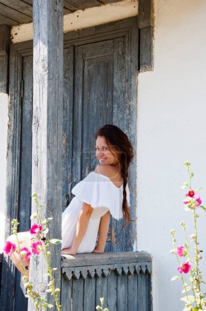 Photo for Young romantic woman in white dress at village cottage house in summer countryside outdoor. Beautiful girl. - Royalty Free Image