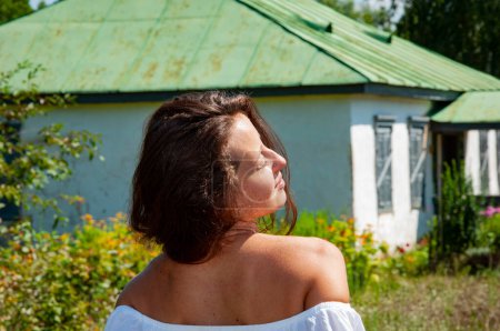 Photo for Countryside happy girl woman in summer Ukrainian village, back view. Summer vacation. Enjoying the sun. Suntan. - Royalty Free Image