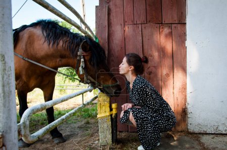 Woman with horse in stable at countryside ranch. Girl horse rider in summer outdoor. Equestrian and horseback riding. Horse stallion equine with Hispanic woman girl. Countryside ranch. Neigh loudly.