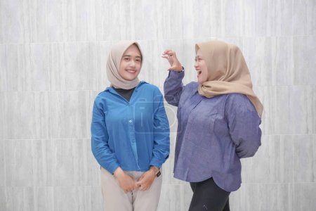 Deux femmes asiatiques indonésiennes portant des hijabs portant des vêtements bleu clair et bleu foncé