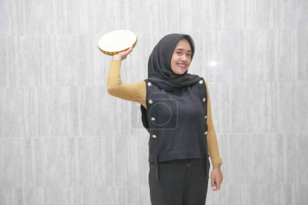 Expresión de una mujer indonesia asiática con un hiyab negro con mangas amarillas