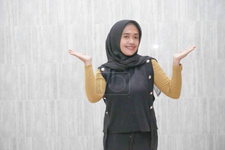 Expression d'une Indonésienne asiatique portant un hijab noir à manches jaunes