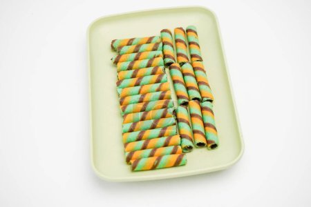 Wafer sticks containing sweet chocolate in a container on a white background