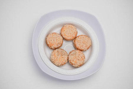 Sesame marie biscuits in a container on a white background