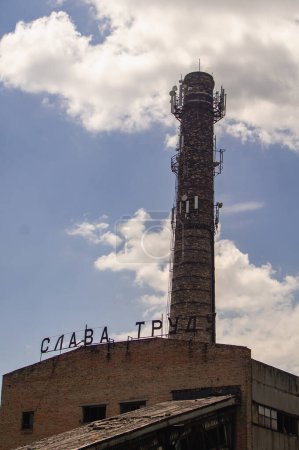 Foto de Fábrica soviética abandonada y chimenea contra el cielo - Imagen libre de derechos