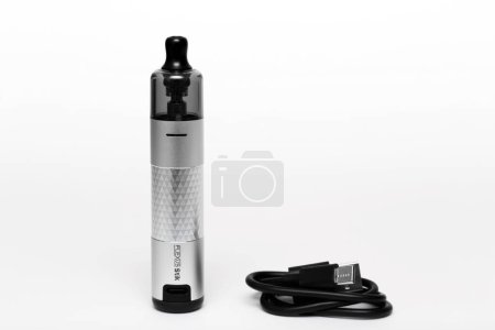 Photo for Ukraine, Odesa - January, 4 2024: Vaping device, vape Aspire Flexus Stik Pod Kit silver color with charging cable USB Type-C on white background, side view. - Royalty Free Image