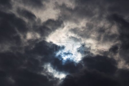 A partial solar eclipse of October 25, 2022 captured through moody dark clouds, the maximal phase visible from Europe, Romania.