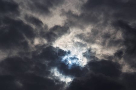 Une éclipse solaire partielle du 25 octobre 2022 capturée à travers des nuages sombres et humides, la phase maximale visible d'Europe, Roumanie.