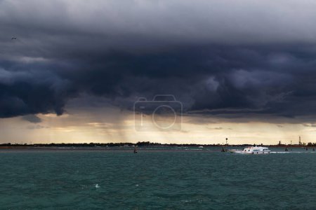 Unbewohnte Inseln der venezianischen Lagune und des Meeres mit dunklem stürmischem Himmel im Hintergrund. Blick von der Insel Murano, Venedig, Italien.
