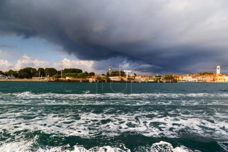 Sant'Elena and San Pietro di Castello island at extreme east end of sestiere of Castello in Venice, Italy. View from Venetian lagoon in stormy weather with dark cloudy sky in background.