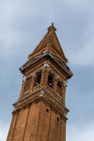Spitze des berühmten schiefen Glockenturms Campanile Pendente der Bischofskirche Saint Martin auf der Insel Burano, Venedig, Italien.